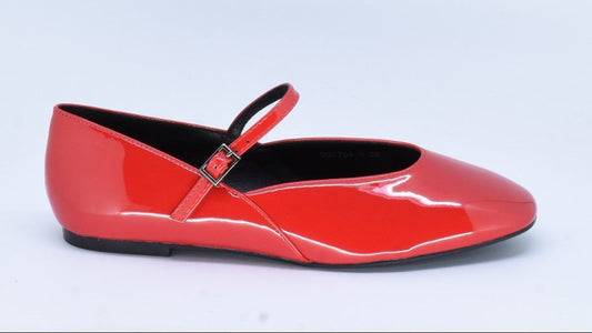 Red patent leather flat shoe with a strap on a light gray background